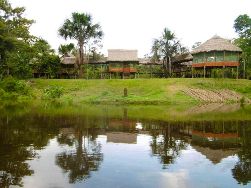 Front view of Antares Amazon Lodge showcasing its rustic wooden architecture surrounded by lush green rainforest vegetation