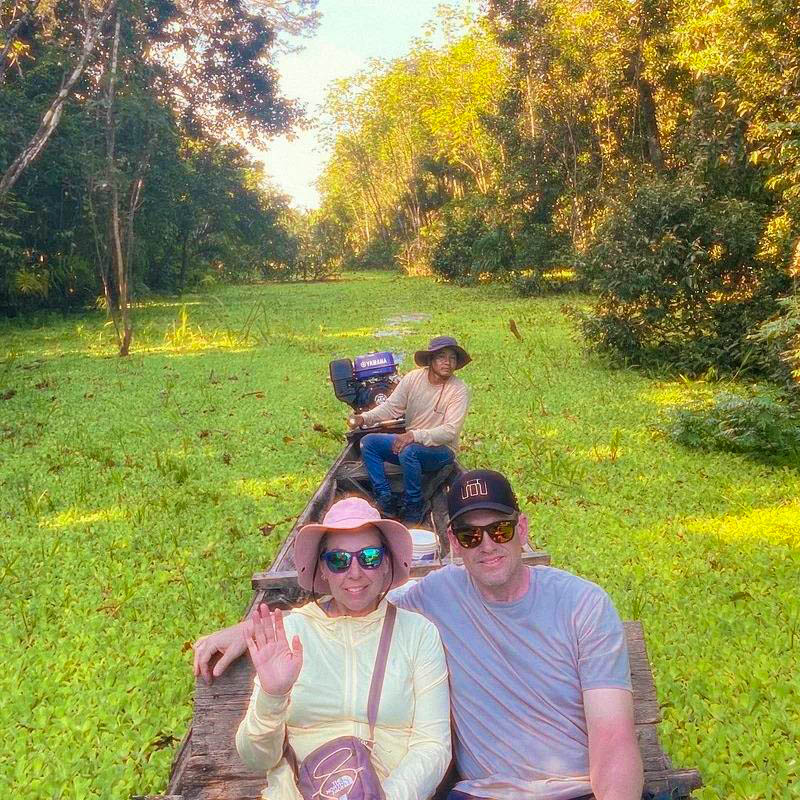 Tourists navigating a boat through the waterways of Pacaya Samiria Reserve, surrounded by lush Amazon rainforest, enjoying eco-tourism and wildlife exploration in the Peruvian Amazon.